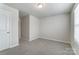 Inviting bedroom with neutral carpet, a window with blinds, and an open doorway at 3936 Cheyney Park Dr, Charlotte, NC 28269