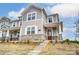 Beautiful two-story townhouse showcasing stone accents, gray siding, and a welcoming front porch entrance at 3936 Cheyney Park Dr, Charlotte, NC 28269