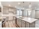 Bright kitchen boasts an island with sink, stainless steel dishwasher, white countertops, and wood-look flooring at 3936 Cheyney Park Dr, Charlotte, NC 28269