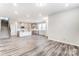 Spacious open-concept living area has wood-look flooring, and a view of the modern kitchen and stairs at 3936 Cheyney Park Dr, Charlotte, NC 28269