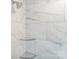 Elegant shower featuring marble tile, glass shelving, and a modern shower head at 3936 Cheyney Park Dr, Charlotte, NC 28269