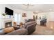 Inviting living room featuring a fireplace, ceiling fan, and open layout to the kitchen with a breakfast bar at 40154 Crooked Stick Dr, Lancaster, SC 29720