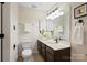 A well-lit bathroom with a dark wood vanity, white countertops, and a large mirror at 5011 Sharon Rd # Q, Charlotte, NC 28210