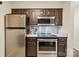 Galley kitchen featuring stainless steel appliances, tile backsplash, and ample storage space at 5011 Sharon Rd # Q, Charlotte, NC 28210
