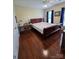 Cozy bedroom with hardwood floors, neutral walls, window with blinds, and ceiling fan at 6017 Lowergate Dr, Waxhaw, NC 28173