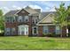 Traditional brick home featuring blue shutters, mature landscaping and a well manicured lawn at 6017 Lowergate Dr, Waxhaw, NC 28173