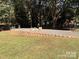Grassy backyard with a retaining wall, rock area, and trees at 625 Wildwood Dr, Rock Hill, SC 29730