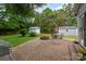 Charming backyard with a brick patio, fire pit, sheds, and green space for outdoor enjoyment at 6512 Porterfield Rd, Charlotte, NC 28226