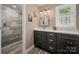 Updated bathroom with dark cabinets, white marble countertops, and a modern shower at 6512 Porterfield Rd, Charlotte, NC 28226