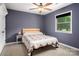Bedroom with hardwood headboard, ceiling fan, and plenty of natural light at 6512 Porterfield Rd, Charlotte, NC 28226