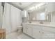 Bright bathroom with double vanity, a modern shower curtain, and white cabinets for storage at 6917 Rothchild Dr, Charlotte, NC 28270
