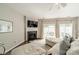 Cozy living room features a modern fireplace with TV, hardwood floors, and sliding glass doors to the patio at 6917 Rothchild Dr, Charlotte, NC 28270