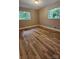 This bedroom features hardwood floors, neutral paint, and two windows at 7021 Linda Lake Dr, Charlotte, NC 28215