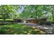 A single-story brick house with an attached carport and surrounding greenery at 7021 Linda Lake Dr, Charlotte, NC 28215