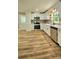 Bright kitchen features white cabinets, stainless steel appliances, gray backsplash, and wood-look flooring at 7021 Linda Lake Dr, Charlotte, NC 28215