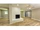 Spacious living room with white brick fireplace, ceiling fan, and wood look flooring at 7021 Linda Lake Dr, Charlotte, NC 28215
