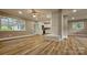 Open living room with hardwood floors, light paint, and brick column that looks into kitchen at 7021 Linda Lake Dr, Charlotte, NC 28215
