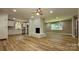 Expansive living room with a white brick fireplace and view into the bright kitchen at 7021 Linda Lake Dr, Charlotte, NC 28215