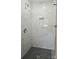 Contemporary shower with marble tile, shower niche, and black hexagon floor at 7021 Linda Lake Dr, Charlotte, NC 28215