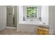 Clean bathroom featuring a soaking tub, glass shower, and bright window at 706 Evans Manor Dr, Weddington, NC 28104