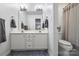 Bathroom featuring double sink vanity, stylish mirror, and separate toilet area with striped shower curtain at 706 Evans Manor Dr, Weddington, NC 28104