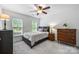 Bright bedroom features a ceiling fan, neutral walls, two windows, and a stylish dark-frame bed at 706 Evans Manor Dr, Weddington, NC 28104