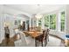 Bright dining area with large windows offering verdant views and an elegant chandelier over the wooden table at 706 Evans Manor Dr, Weddington, NC 28104