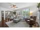 Bright living room featuring white sofas, plantation shutters, and hardwood floors at 706 Evans Manor Dr, Weddington, NC 28104