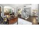 Home office with a wooden desk and chair, view into the dining area and staircase to the upper level at 706 Evans Manor Dr, Weddington, NC 28104