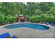 Captivating pool area surrounded by lush greenery, a charming cabana, and cozy seating arrangements at 706 Evans Manor Dr, Weddington, NC 28104