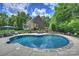 Inviting backyard features a kidney-shaped pool, manicured landscaping, and a brick home in the background at 706 Evans Manor Dr, Weddington, NC 28104