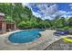 Beautiful backyard with a large pool, lush greenery, comfortable seating, and a relaxing ambiance at 706 Evans Manor Dr, Weddington, NC 28104