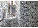 Stylish powder room with patterned wallpaper, gold fixtures, and a pedestal sink at 706 Evans Manor Dr, Weddington, NC 28104