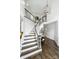 Elegant staircase with dark wood trim and white risers, complemented by modern chandelier at 706 Evans Manor Dr, Weddington, NC 28104