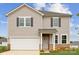 Two-story home showcasing gray siding, black shutters, a two-car garage, and a covered entryway at 710 Olde England Dr, Lincolnton, NC 28092