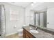 Well-lit bathroom featuring a granite countertop, framed mirror, and shower with modern fixtures at 7316 Hamilton Bridge Rd, Charlotte, NC 28278