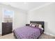 Comfortable bedroom with a patterned purple quilt, dresser, and bright window at 7316 Hamilton Bridge Rd, Charlotte, NC 28278
