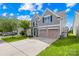 Inviting two-story home features a well-maintained lawn and a convenient two-car garage, all under a bright, sunny sky at 7316 Hamilton Bridge Rd, Charlotte, NC 28278