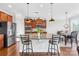 Spacious kitchen features granite counters, stainless appliances, wood cabinets, eat-in dining and pendant lighting at 7316 Hamilton Bridge Rd, Charlotte, NC 28278