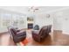 Cozy living room with large windows, ceiling fan, fireplace, and comfortable leather seating at 7316 Hamilton Bridge Rd, Charlotte, NC 28278