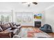 Cozy living room with large windows, fireplace, ceiling fan, and plush leather furniture at 7316 Hamilton Bridge Rd, Charlotte, NC 28278