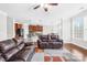 Open concept living room and kitchen area with large windows, fireplace, and leather couches at 7316 Hamilton Bridge Rd, Charlotte, NC 28278