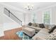 A sunlit living room with hardwood floors, a staircase, and comfortable seating area at 7316 Hamilton Bridge Rd at 7316 Hamilton Bridge Rd, Charlotte, NC 28278