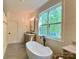 Bright bathroom featuring a soaking tub, wood-framed mirrors, and a large window with wooded views at 762 Highway 274 Hwy, Clover, SC 29710