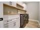 Functional laundry room with washer, dryer, built-in cabinets, and wood shelves at 762 Highway 274 Hwy, Clover, SC 29710