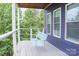 Charming covered deck with a cozy porch swing, providing a perfect spot for relaxation and enjoying nature at 7768 Pinecone Ln, Hickory, NC 28602