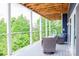 Covered deck with comfortable seating offers relaxing views of the lush greenery at 7768 Pinecone Ln, Hickory, NC 28602