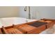 Close up view of an elegant soaking tub with wood shelf and fixtures at 7768 Pinecone Ln, Hickory, NC 28602