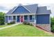 Lovely blue home with charming front porch, white railing and lush green lawn at 7768 Pinecone Ln, Hickory, NC 28602