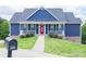 Charming blue two-story home with a red front door and white railings leading to a well-manicured lawn at 7768 Pinecone Ln, Hickory, NC 28602